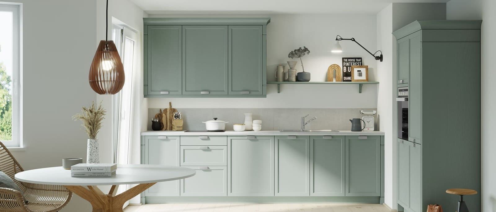 Sage green kitchen with a round table and full-height storage